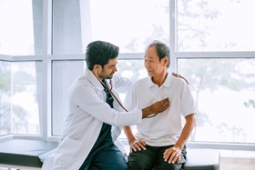 Male doctor with an elder heart patient