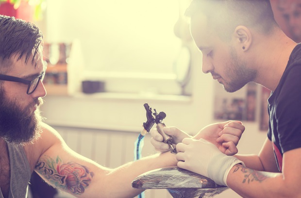 man getting a tattoo on his arm
