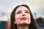 Young woman with a hopeful look, her face is pointed skyward 