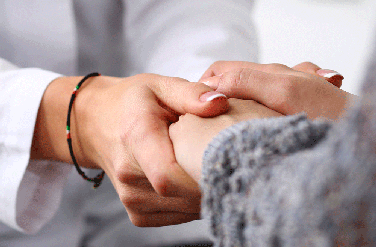 Closeup of doctor holding patient's hand