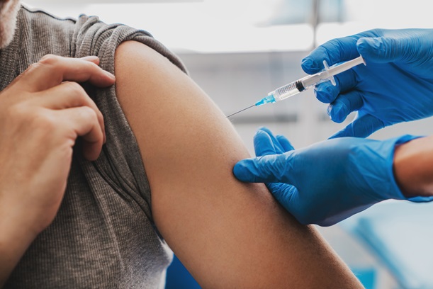 A vaccine being administered via a person's bicep.