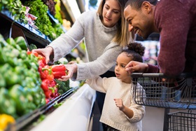 Family selecting produce at a grocery store