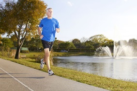 man running on road by water