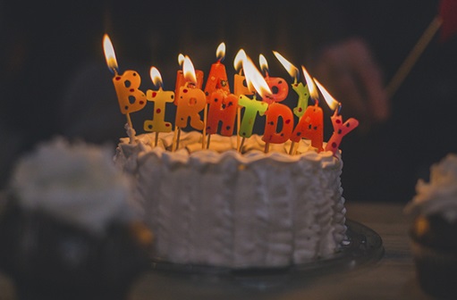 Lit Happy Birthday candles on cake