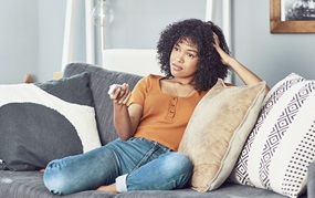 young female sitting on couch watching tv