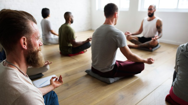 group of people meditating in a room