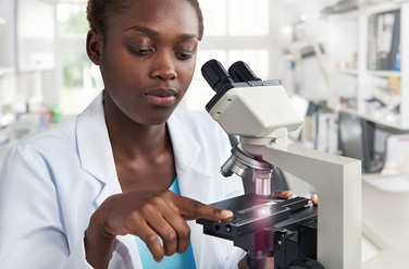 Female Scientist With Microscope in Lab