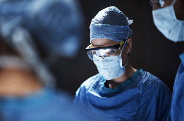 Closeup of three surgeons in operating room