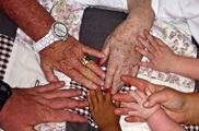 Older and younger family member hands in a circle