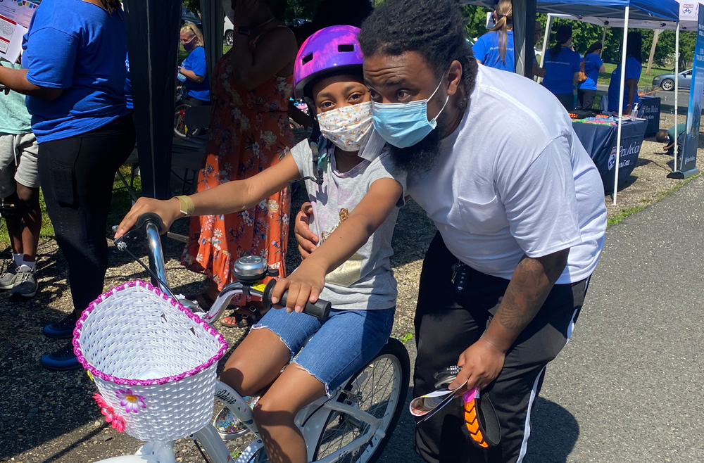 Naomi, 8, and her dad pose with new bike, featuring a basket and a bell
