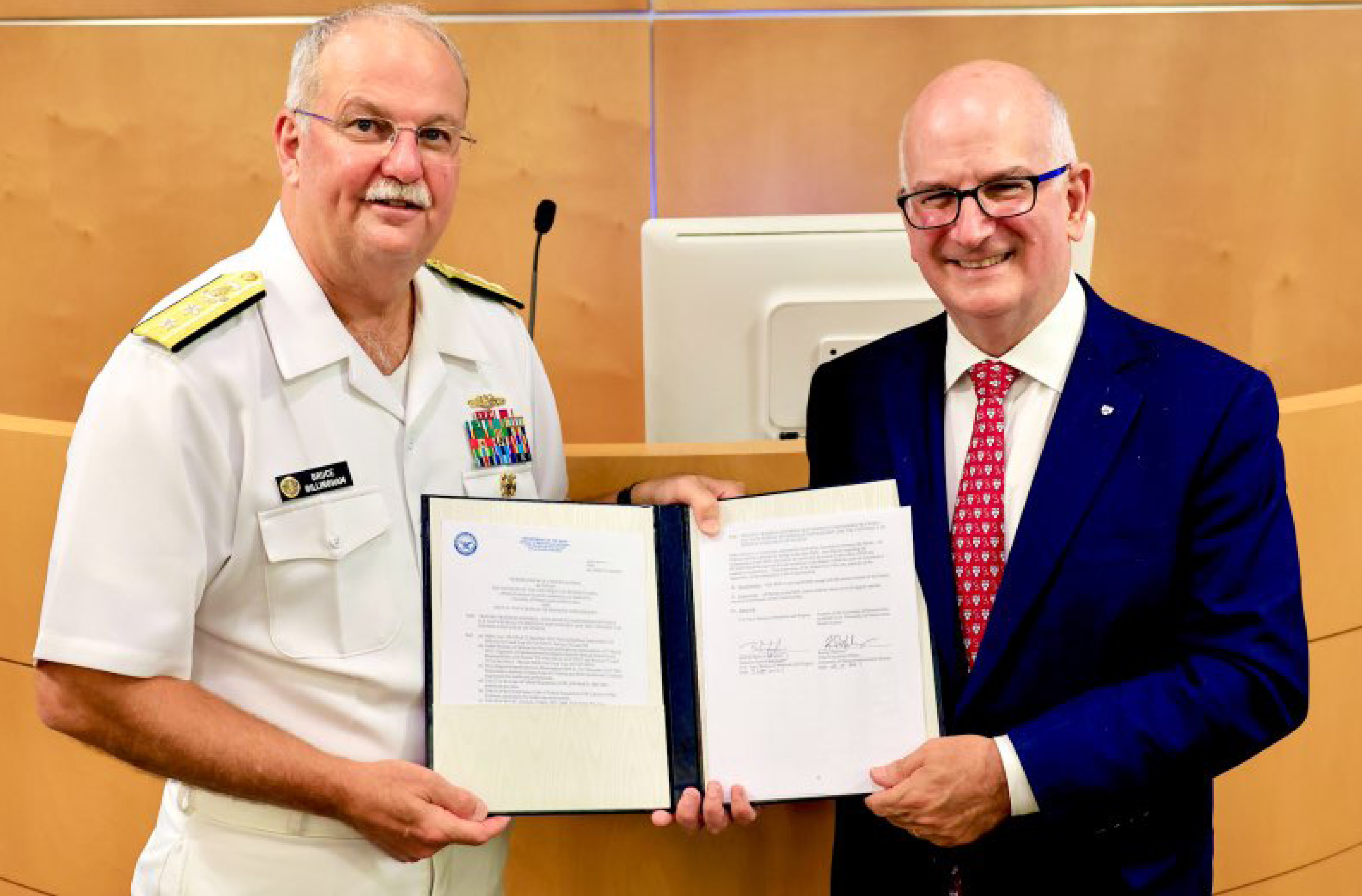 Kevin Mahoney and Rear Admiral Bruce Gillingham, Navy Surgeon General, display the signed partnership agreement