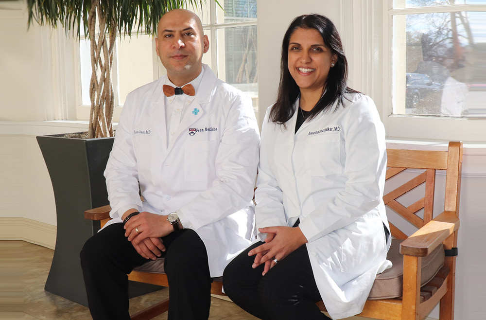 Kevin Sowti, MD, MBA, and Aneesha Dhargalkar, MD sitting on a bench