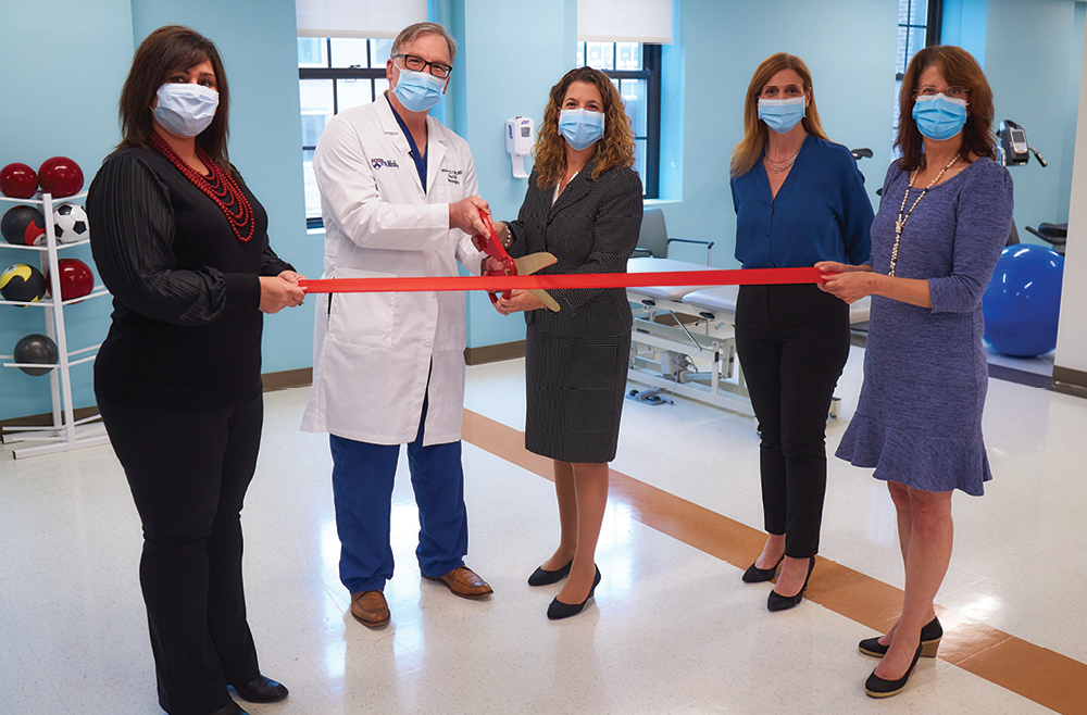 Group of five employees cut ribbon marking the opening of Penn Therapy and Fitness on the 7th floor of Pennsylvania Hospital’s Spruce Building