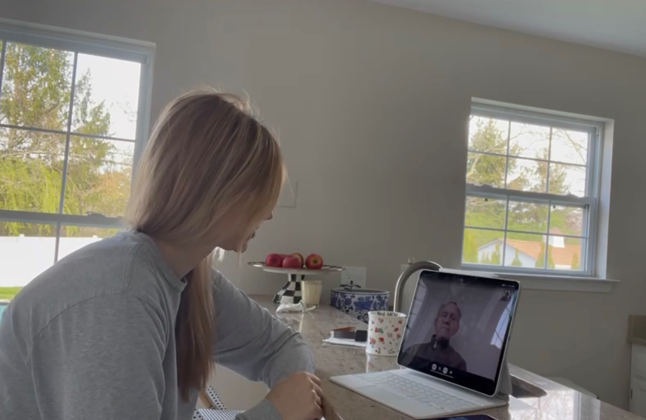 Alena Blain speaks with her godfather on a virtual call on her laptop