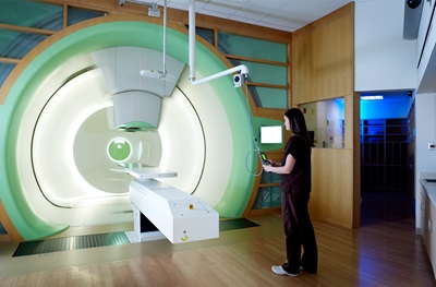 Doctor standing next to proton therapy machine