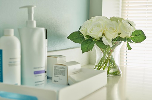 Bathroom counter with skin care products and white flowers